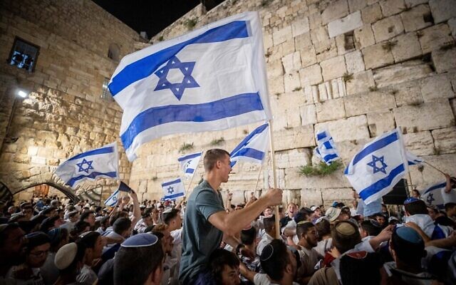 Des Juifs dansent avec des drapeaux d'Israël au mur Occidental, à la veille de Yom Yeroushalayim, le 9 mai 2021. (Crédit : Yonatan Sindel/Flash90) Des Juifs dansent avec des drapeaux d'Israël au mur Occidental, à la veille de Yom Yeroushalayim, le 9 mai 2021. (Crédit : Yonatan Sindel/Flash90)
