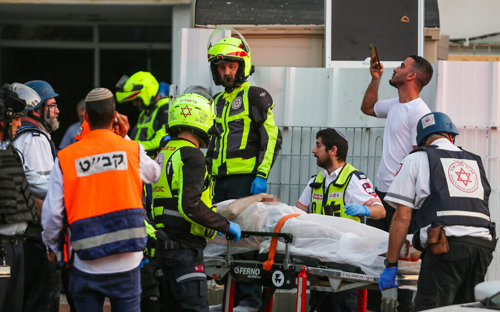 Des secouristes évacuent un homme blessé sur les lieux où un immeuble d'habitation a été touché par une roquette tirée depuis la bande de Gaza à Ashkelon, dans le sud d'Israël, le 11 mai 2021. (Edi Israel/Flash90)