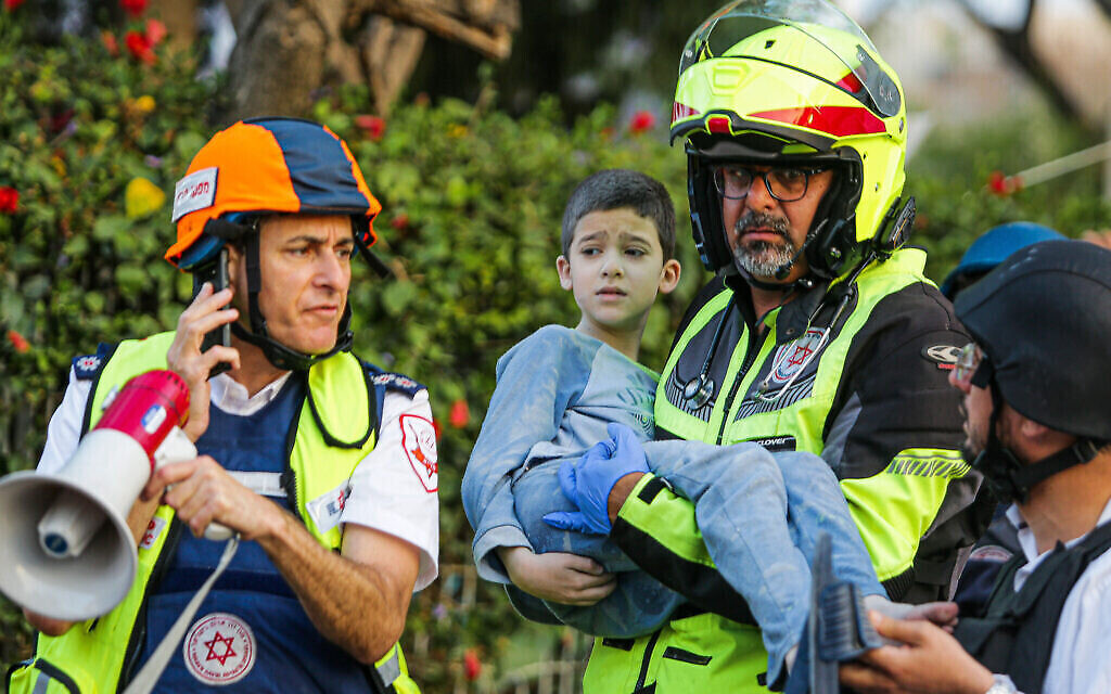 Un secouriste transporte un enfant blessé sorti d'un immeuble d'appartement touché par une roquette tirée depuis Daza à Ashkelon, le 11 mai 2021. (Crédit : Flash90)