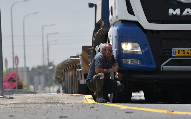 Un chauffeur de camion s'abrite pendant une alerte à la roquette près d'Ashkelon, le 12 mai 2021. (Crédit : Gili Yaari/Flash90)