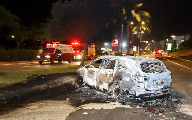 Une voiture incendiée par des résidents arabes pendant des émeutes et des affrontements entre résidents arabes et juifs à Lod, dans le centre d'Israël, le 12 décembre 2021. (Crédit : Yossi Aloni/FLASH90)