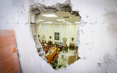 Les forces de sécurité dans une synagogue frappée par une roquette tirée depuis la bande de Gaza à Ashkelon, dans le sud d'Israël, le 16 mai 2021. (Crédit : Avi Roccah/Flash90)