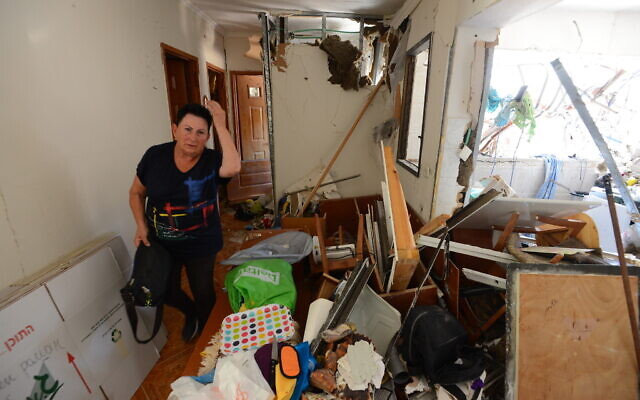 Une Israélienne dans les décombres de sa maison détruite par un tir de roquette, à Ashdod, le 18 mai 2021. (Crédit : Avi Roccah/Flash90)