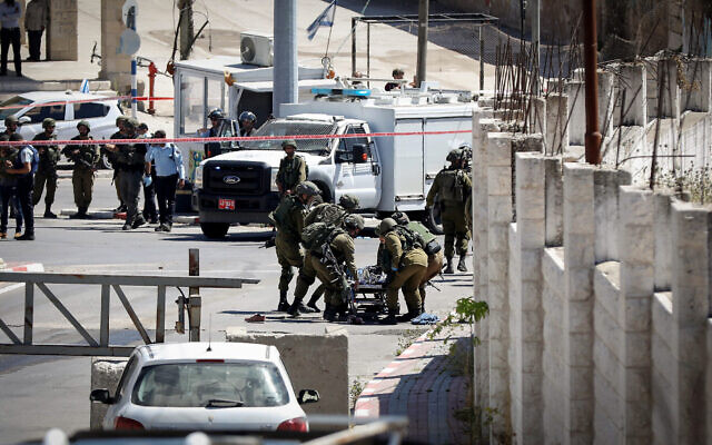 Les soldats israéliens sur le site où un Palestinien a tenté d'attaquer des militaires en ouvrant le feu et en tentant de jeter une bombe avant d'être abattu, à Hébron, le 18 mai 2021. (Crédit : Wisam Hashlamoun/FLASH90)