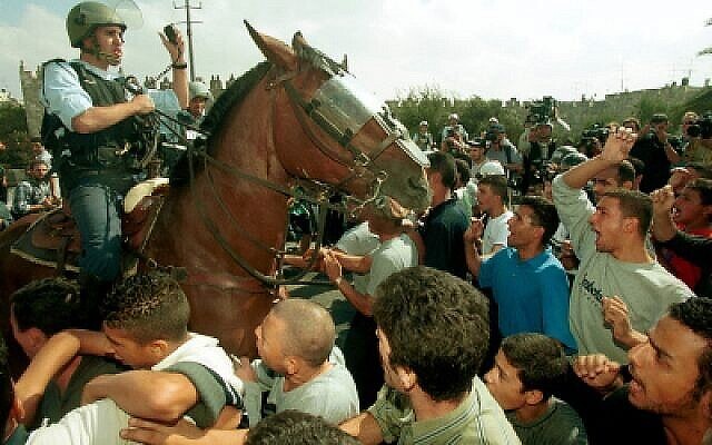 Un policier à cheval au milieu d'une foule d’Arabes israéliens lors d'affrontements au début de la Seconde Intifada, le 20 octobre 2000. (Flash90) Un policier à cheval au milieu d'une foule d’Arabes israéliens lors d'affrontements au début de la Seconde Intifada, le 20 octobre 2000. (Flash90)