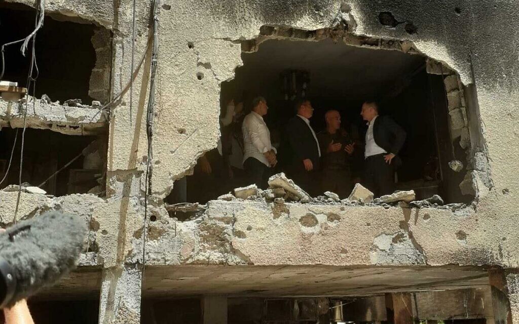 Le ministre allemand des Affaires étrangères, Heiko Maas, visite un bâtiment à Petah Tikva touché par une roquette tirée depuis la bande de Gaza, le 20 mai 2021. (Crédit : Miri Shimonovitch).