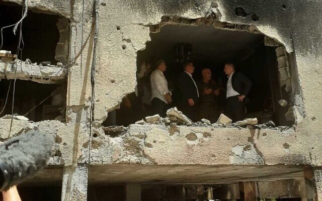 Le ministre allemand des Affaires étrangères, Heiko Maas, visite un bâtiment à Petah Tikva touché par une roquette tirée depuis la bande de Gaza, le 20 mai 2021. (Crédit : Miri Shimonovitch).