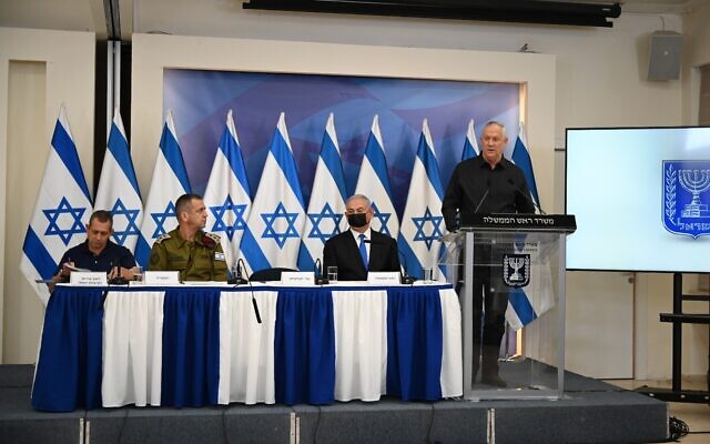 De gauche à droite : le chef du Shin Bet Nadav Argaman, le chef d'État-major de l'armée israélienne Aviv Kohavi, le Premier ministre Benjamin Netanyahu et le ministre de la Défense Benny Gantz, lors d'une conférence de presse à l'issue du cessez-le-feu avec Gaza, au siège de l'armée à Tel Aviv, le 21 mai 2021. (Crédit : Tal Oz/Defense Ministry) De gauche à droite : le chef du Shin Bet Nadav Argaman, le chef d'État-major de l'armée israélienne Aviv Kohavi, le Premier ministre Benjamin Netanyahu et le ministre de la Défense Benny Gantz, lors d'une conférence de presse à l'issue du cessez-le-feu avec Gaza, au siège de l'armée à Tel Aviv, le 21 mai 2021. (Crédit : Tal Oz/Defense Ministry)