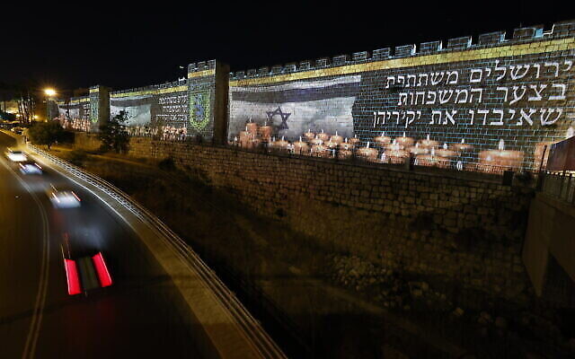 Les murs de la Vieille Ville de Jérusalem illuminés par le drapeau israélien et des bougies à la mémoire des 45 victimes tuées dans la bousculade au mont Meron lors des célébrations de Lag B’Omer, le 1er mai 2021. (Crédit : Yonatan Sindel / Flash90) Les murs de la Vieille Ville de Jérusalem illuminés par le drapeau israélien et des bougies à la mémoire des 45 victimes tuées dans la bousculade au mont Meron lors des célébrations de Lag B’Omer, le 1er mai 2021. (Crédit : Yonatan Sindel / Flash90)