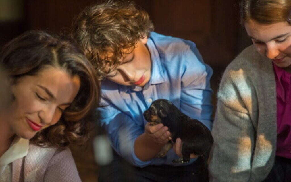 De droite à gauche : Ayelet Zurer dans le rôle de Shoshana, August Maturo dans le rôle de Joshua, et Viktoria Stefanovszky dans le rôle de Rachel avec le chiot Caleb dans 'Shepherd : The Story of a Jewish Dog" 
(Crédit : JDog Films)
