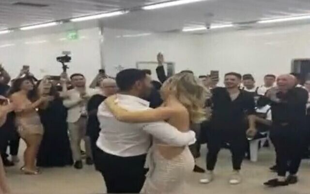 Les convives dansent autour de Loren et David, dont le mariage a été interrompu par des sirènes d'alerte à la roquette, le 19 mai 2021. (Capture d'écran Douzième chaîne) Les convives dansent autour de Loren et David, dont le mariage a été interrompu par des sirènes d'alerte à la roquette, le 19 mai 2021. (Capture d'écran Douzième chaîne)