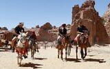 Des touristes montent à dos d'âne et de cheval lors de la visite de la cité antique de Petra, en Jordanie, le 27 mai 2021, après sa réouverture suite à la fermeture due à la pandémie de coronavirus Covid-19. (Crédit : Khalil MAZRAAWI / AFP)