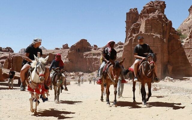 Des touristes montent à dos d'âne et de cheval lors de la visite de la cité antique de Petra, en Jordanie, le 27 mai 2021, après sa réouverture suite à la fermeture due à la pandémie de coronavirus Covid-19. (Crédit : Khalil MAZRAAWI / AFP) Des touristes montent à dos d'âne et de cheval lors de la visite de la cité antique de Petra, en Jordanie, le 27 mai 2021, après sa réouverture suite à la fermeture due à la pandémie de coronavirus Covid-19. (Crédit : Khalil MAZRAAWI / AFP)