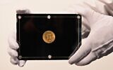 Un employé de Sothebys tient une pièce Double Eagle de 1933 pendant la vente aux enchères en direct "Three Treasures Collected by Stuart Weitzman" de trois trésors de la collection personnelle du créateur de mode et collectionneur. (Crédit : Angela Weiss / AFP)