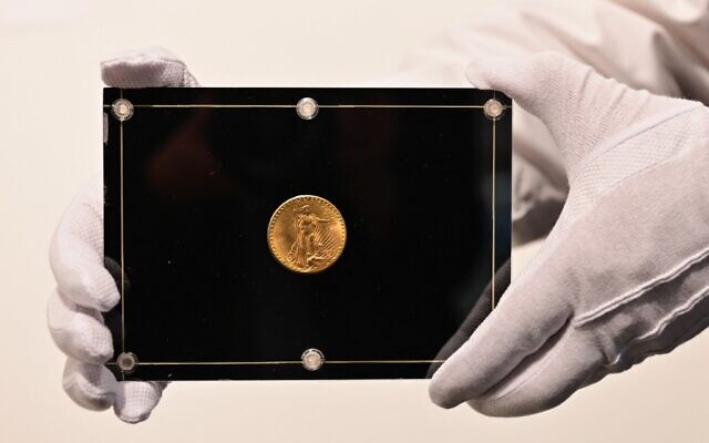 Un employé de Sothebys tient une pièce Double Eagle de 1933 pendant la vente aux enchères en direct "Three Treasures Collected by Stuart Weitzman" de trois trésors de la collection personnelle du créateur de mode et collectionneur. (Crédit : Angela Weiss / AFP) Un employé de Sothebys tient une pièce Double Eagle de 1933 pendant la vente aux enchères en direct "Three Treasures Collected by Stuart Weitzman" de trois trésors de la collection personnelle du créateur de mode et collectionneur. (Crédit : Angela Weiss / AFP)