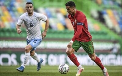 L'attaquant portugais Cristiano Ronaldo contrôle le ballon à côté du milieu de terrain israélien Neta Lavi (g) lors du match de football amical international entre le Portugal et Israël au stade José Alvalade à Lisbonne en préparation de la compétition de football UEFA EURO 2020, le 9 juin 2021. (Crédit : PATRICIA DE MELO MOREIRA / AFP)