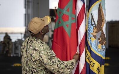 Un membre de la marine américaine vérifie le drapeau marocain sur le navire de la marine américaine "Hershel Woody Williams" lors de l'exercice militaire "African Lion", le 11 juin 2021 dans la ville d'Agadir au Maroc. (Crédit : FADEL SENNA / AFP)