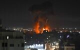 Des explosions illuminent le ciel nocturne au-dessus des bâtiments de la ville de Gaza, alors que les forces israéliennes bombardent l'enclave palestinienne, tôt le 16 juin 2021. (Crédit 
: MAHMUD HAMS / AFP)