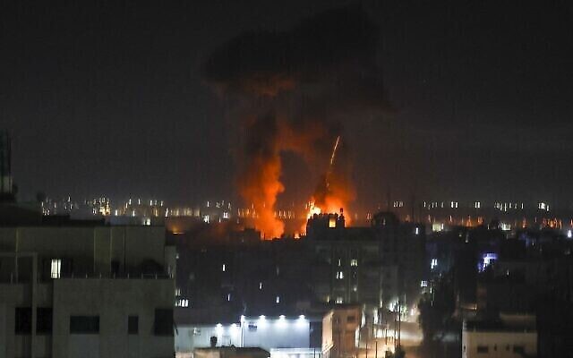 Des explosions illuminent le ciel nocturne au-dessus des bâtiments de la ville de Gaza, alors que les forces israéliennes bombardent l'enclave palestinienne, tôt le 16 juin 2021. (Crédit 
: MAHMUD HAMS / AFP)