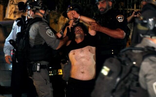 Un manifestant palestinien est arrêté par les forces de sécurité israéliennes dans le quartier de Sheikh Jarrah lors d'affrontements avec les résidents juifs, le 21 juin 2021. (Crédit : AHMAD GHARABLI / AFP) Un manifestant palestinien est arrêté par les forces de sécurité israéliennes dans le quartier de Sheikh Jarrah lors d'affrontements avec les résidents juifs, le 21 juin 2021. (Crédit : AHMAD GHARABLI / AFP)
