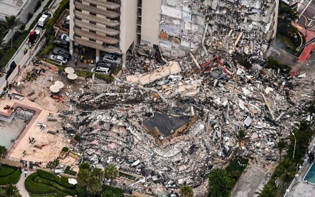 Vue aérienne des efforts du personnel de recherche et de sauvetage sur le site de l'effondrement partiel des Champlain Towers South à Surfside, au nord de Miami Beach, le 24 juin 2021. (Crédit : CHANDAN KHANNA / AFP) Vue aérienne des efforts du personnel de recherche et de sauvetage sur le site de l'effondrement partiel des Champlain Towers South à Surfside, au nord de Miami Beach, le 24 juin 2021. (Crédit : CHANDAN KHANNA / AFP)