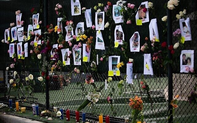 Des photos de résidents disparus sont affichées sur un mémorial de fortune sur le site d'un immeuble effondré à Surfside, en Floride, au nord de Miami Beach, le 26 juin 2021. (Crédit : Andrea Sarcos / AFP) Des photos de résidents disparus sont affichées sur un mémorial de fortune sur le site d'un immeuble effondré à Surfside, en Floride, au nord de Miami Beach, le 26 juin 2021. (Crédit : Andrea Sarcos / AFP)