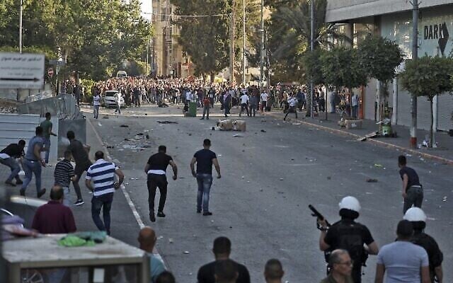 Des manifestants palestiniens affrontent les forces de sécurité palestiniennes dans la ville de Ramallah, en Cisjordanie , le 26 juin 2021, à la suite d'une manifestation contre la mort du militant des droits de l'homme Nizar Banat. (Crédit : ABBAS MOMANI / AFP)