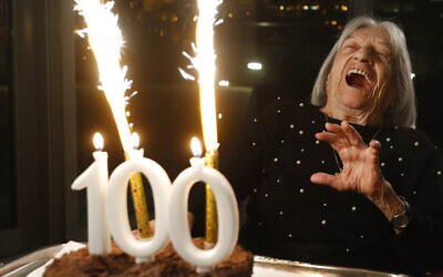 Agnes Keleti, l'une des plus anciennes survivantes de la Shoah encore en vie en 2023 et ancienne gymnaste médaillée d'or olympique, réagit au feu d'artifice qui éclate sur son gâteau d'anniversaire à Budapest, en Hongrie, lundi 4 janvier 2021. (Crédit : Laszlo Balogh/AP)