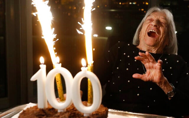 Agnes Keleti, l'une des plus anciennes survivantes de la Shoah encore en vie en 2023 et ancienne gymnaste médaillée d'or olympique, réagit au feu d'artifice qui éclate sur son gâteau d'anniversaire à Budapest, en Hongrie, lundi 4 janvier 2021. (Crédit : Laszlo Balogh/AP) Agnes Keleti, l'une des plus anciennes survivantes de la Shoah encore en vie en 2023 et ancienne gymnaste médaillée d'or olympique, réagit au feu d'artifice qui éclate sur son gâteau d'anniversaire à Budapest, en Hongrie, lundi 4 janvier 2021. (Crédit : Laszlo Balogh/AP)