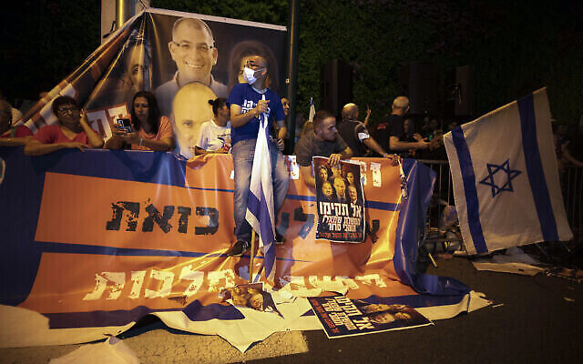 Des manifestants israéliens de droite scandent des slogans et brandissent des drapeaux lors d'une manifestation contre la formation d'un nouveau gouvernement dans la ville centrale d'Israël de Ramat Gan, le mercredi 2 juin 2021. (Crédit: AP/Sebastian Scheiner) Des manifestants israéliens de droite scandent des slogans et brandissent des drapeaux lors d'une manifestation contre la formation d'un nouveau gouvernement dans la ville centrale d'Israël de Ramat Gan, le mercredi 2 juin 2021. (Crédit: AP/Sebastian Scheiner)