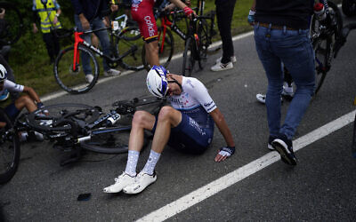 Chris Froome est allongé sur la route après avoir chuté lors de la première étape du Tour de France, le 26 juin 2021. (Crédit : AP Photo/Daniel Cole)