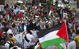Des Palestiniens agitent des drapeaux nationaux lors d'une manifestation contre la normalisation des liens entre les Emirats arabes unis et le Bahreïn avec Israël, dans la ville de Ramallah, en Cisjordanie, le 15 septembre 2020. (Crédit : Majdi Mohammed/AP)