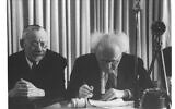 David Ben Gurion signe la déclaration d'indépendance israélienne, le 29 novembre 1947. (Crédit : Hans Pinn/GPO)