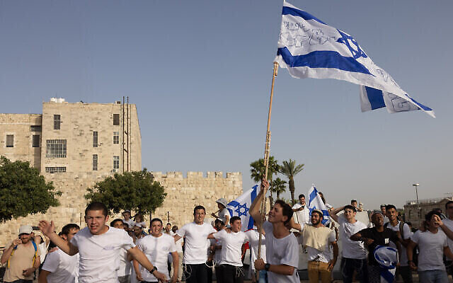 De jeunes Juifs dansent avec des drapeaux israéliens aux abords de la Vieille Ville de Jérusalem, le 10 mai 2021. (Crédit : Nati Shohat/Flash90) De jeunes Juifs dansent avec des drapeaux israéliens aux abords de la Vieille Ville de Jérusalem, le 10 mai 2021. (Crédit : Nati Shohat/Flash90)