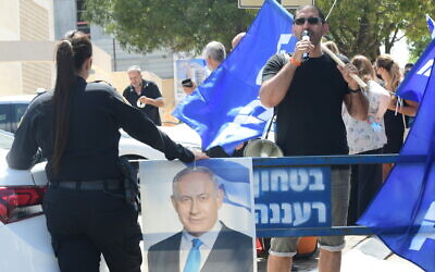 Un homme utilise un haut-parleur lors d'une manifestation organisée devant l'habitation du leader du parti Yamina,  Naftali Bennet, lors des négociations visant à former un gouvernement à Raanana, le 4 juin 2021. (Crédit : Avshalom Sassoni/Flash90)