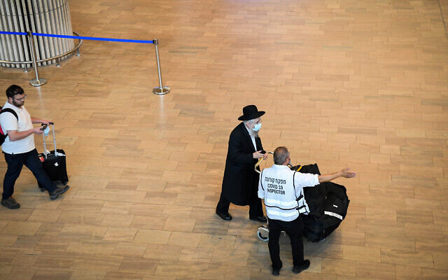 Des voyageurs arrivent à l'aéroport Ben Gurion, le 23 juin 2021. (Crédit :  Flash90)