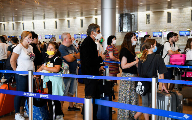 Des voyageurs masqués rassemblés à l'aéroport Ben-Gurion, dans le hall des départs, le 23 juin 2021. (Crédit : Flash90) Des voyageurs masqués rassemblés à l'aéroport Ben-Gurion, dans le hall des départs, le 23 juin 2021. (Crédit : Flash90)