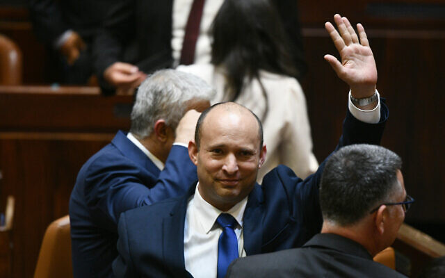 Le nouveau Premier ministre élu Naftali Bennett fait un signe de la main avec Yair Lapid, à sa gauche, et Gideon Saar, à sa droite, à ses côtés, après l'approbation de leur nouveau gouvernement à la Knesset, le 13 juin 2021. (Crédit : Haim Zach / GPO) Le nouveau Premier ministre élu Naftali Bennett fait un signe de la main avec Yair Lapid, à sa gauche, et Gideon Saar, à sa droite, à ses côtés, après l'approbation de leur nouveau gouvernement à la Knesset, le 13 juin 2021. (Crédit : Haim Zach / GPO)