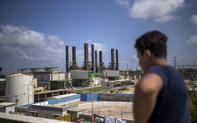 Un Palestinien, sur le toit de sa maison, regarde la centrale électrique de Gaza après sa fermeture, dans la ville de Nusairat, au centre de la bande de Gaza, le 18 août 2020. (Crédit : AP Photo/ Khalil Hamra) Un Palestinien, sur le toit de sa maison, regarde la centrale électrique de Gaza après sa fermeture, dans la ville de Nusairat, au centre de la bande de Gaza, le 18 août 2020. (Crédit : AP Photo/ Khalil Hamra)