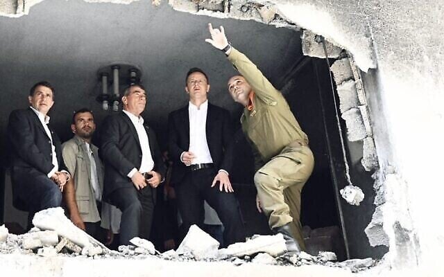 Le ministre des Affaires Etrangères, Gabi Ashkenazi et son homologue hongrois, Peter Szijjartoon, visitent une maison dans la ville centrale de Petah Tikva qui a été touchée par une roquette tirée par des terroristes palestiniens à Gaza pendant l'opération de Tsahal "Gardien des murs", le 1er juin 2021. (Crédit : Courtoisie)