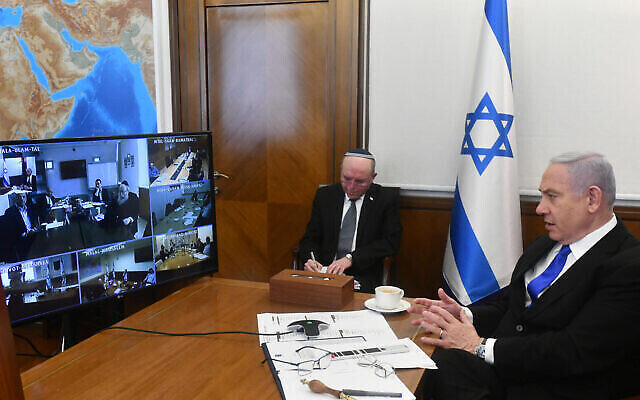 Illustration : Le Premier ministre Benjamin Netanyahu (R) tient la réunion hebdomadaire du cabinet par appel de vidéoconférence depuis le bureau du Premier ministre à Jérusalem en raison de la réglementation sur le coronavirus, le 15 mars 2020. (Haim Zach/GPO)