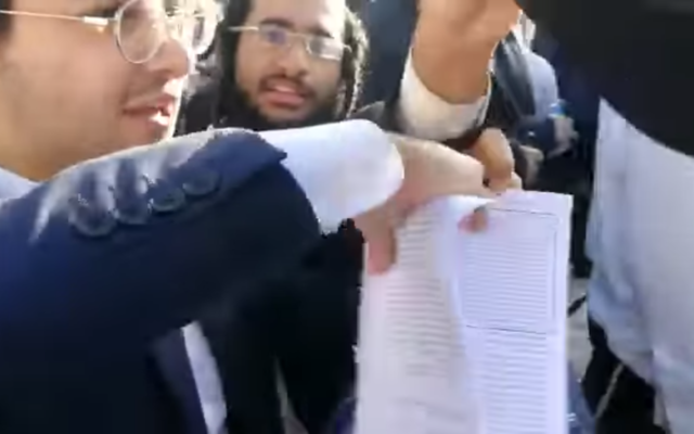 Des extrémistes haredim déchirent des livres de prière des fidèles des Femmes du mur au mur Occidental, le 11 juin 2021. (Capture d'écran/Facebook)