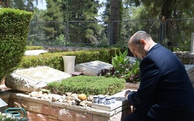 Naftali Bennett se rend sur la tombe du lieutenant-colonel Emmanuel Moreno, au Mont Herzl à Jérusalem, le 14 juin 2021. (Crédit : Amos Ben-Gershom/GPO)
