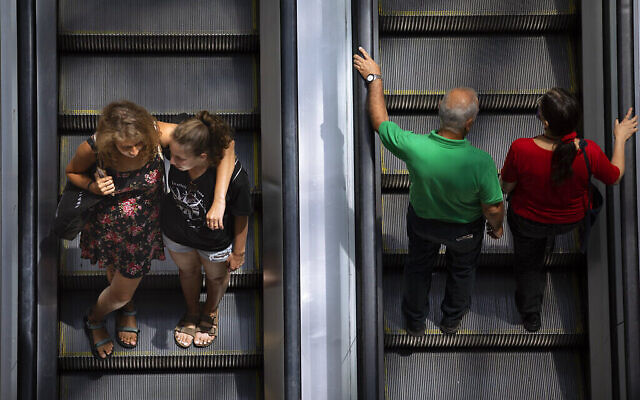 Des personnes empruntent un escalator dans un centre commercial après la levée des restrictions imposant le port de masques à l'intérieur, à Tel Aviv, le mardi 15 juin 2021. (AP Photo/Oded Balilty) Des personnes empruntent un escalator dans un centre commercial après la levée des restrictions imposant le port de masques à l'intérieur, à Tel Aviv, le mardi 15 juin 2021. (AP Photo/Oded Balilty)