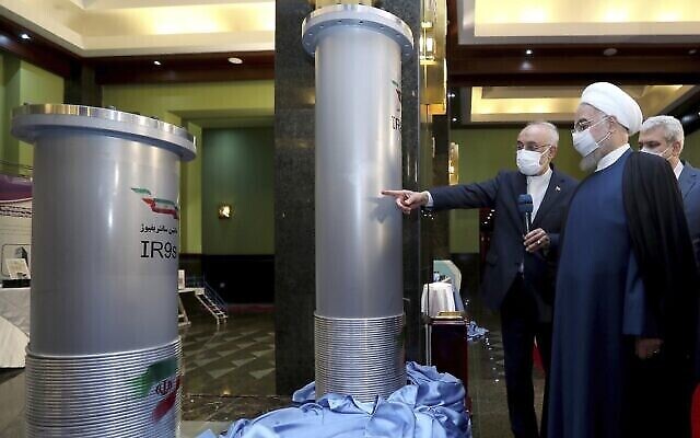 Le président iranien Hassan Rouhani, deuxième à droite, écoute le chef de l'Organisation iranienne de l'énergie atomique, Ali Akbar Salehi, alors qu'il visite une exposition sur les nouvelles réalisations nucléaires de l'Iran à Téhéran, en Iran, le 10 avril 2021. (Bureau de la présidence iranienne via AP)