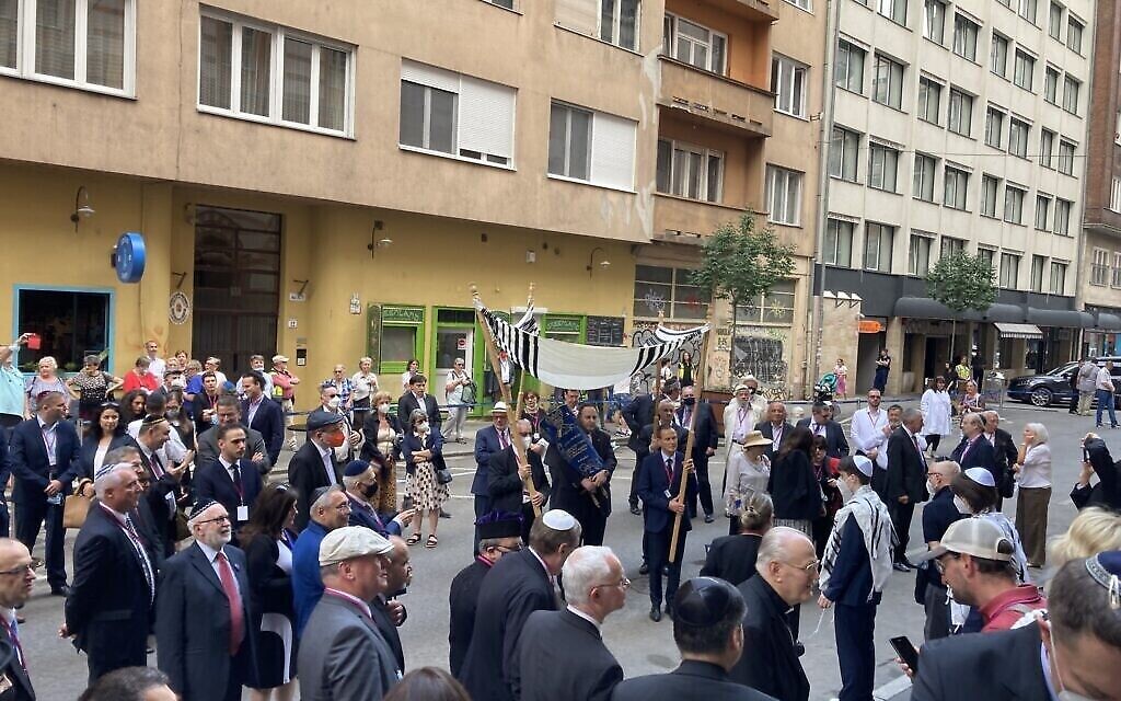 Des membres de la communauté juive de Budapest dansent avec la Torah devant la synagogue Rumbach, le 10 juin 2021. (Yaakov Schwartz/ Times of Israel)