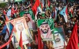 Des gens défilent avec des drapeaux du sud-Yémen, des EAU et de l'Arabie saoudite ainsi que des portraits du roi saoudien Salman bin Abdulaziz, au centre-gauche, du prince Prince Mohammed bin Salman, au centre à droite, du président des EAU Khalifa bin Zayed al-Nahyan (à gauche) et de son frère, le prince héritier d'Abu Dhabi Mohammed bin Zayed al-Nahyan (à droite) pensant un défilé à Aden, la seconde ville la plus grande du Yémen, le 5 septembre 2019. (Crédit : Saleh Al-OBEIDI/AFP)
