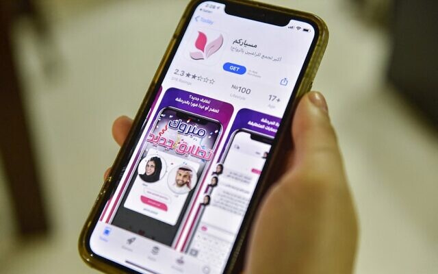 Une femme avec un smartphone à la main montrant une application de mariage "Misyar" en Arabie saoudite, le 29 octobre 2020. (Crédit :  FAYEZ NURELDINE / AFP)