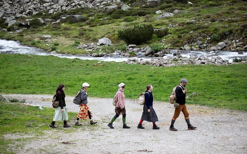 Des spectateurs suivent la troupe de théâtre Teatro Caprile à l'alpage Windbach dans les Alpes de Krimmler Tauern, à la frontière entre l'Autriche et l'Italie, en direction du col de Krimmler, près de Krimml, le 25 juin 2021.(ALEX HALADA/AFP)
