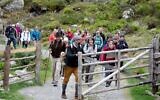 Des spectateurs suivent la troupe de théâtre Teatro Caprile à l'alpage Windbach dans les Alpes de Krimmler Tauern, à la frontière entre l'Autriche et l'Italie, en direction du col de Krimmler, près de Krimml, le 25 juin 2021.(ALEX HALADA/AFP)